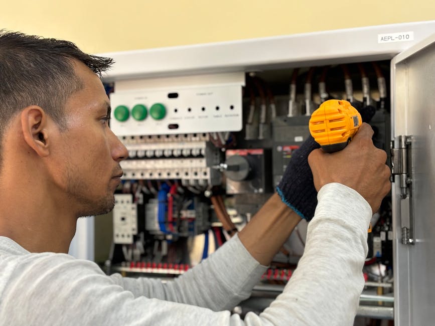 pexels-photo-27928761-27928761 Skilled electrician using a drill to repair electrical equipment indoors. Focus on precision and safety.